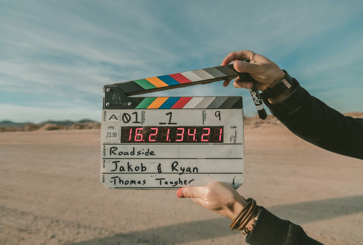 Clap de tournage tenu en main sur un plateau en extérieur